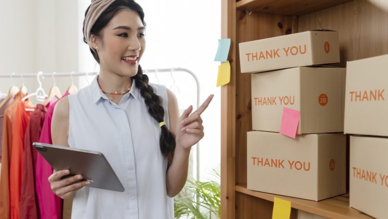 Entrepreneur Asian young woman sell clothes check order product working at home. start-up small business owner, SME or freelance business online and delivery concept.